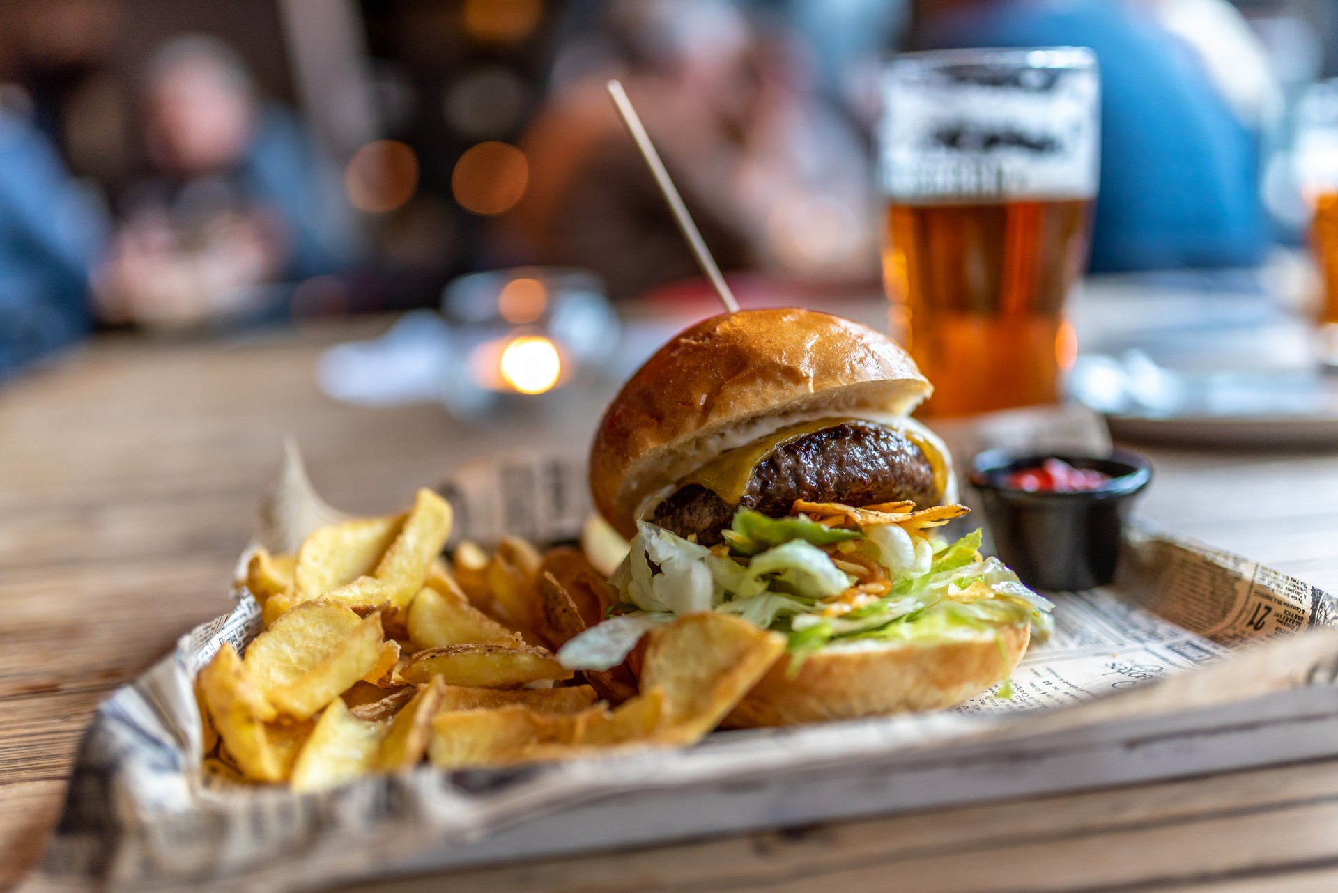 A Burger with French Fries on the Side and a craft beer